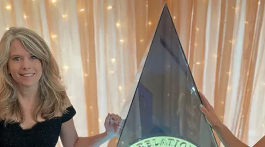 KSC Team members pose with NAVC’s team member in front of a giant Golden Image Award at the 2024 Golden Image Awards Gala.